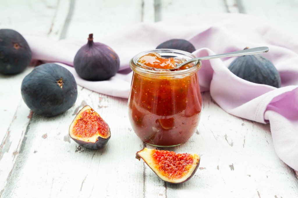 jar of fig jam with cut and whole figs in frame