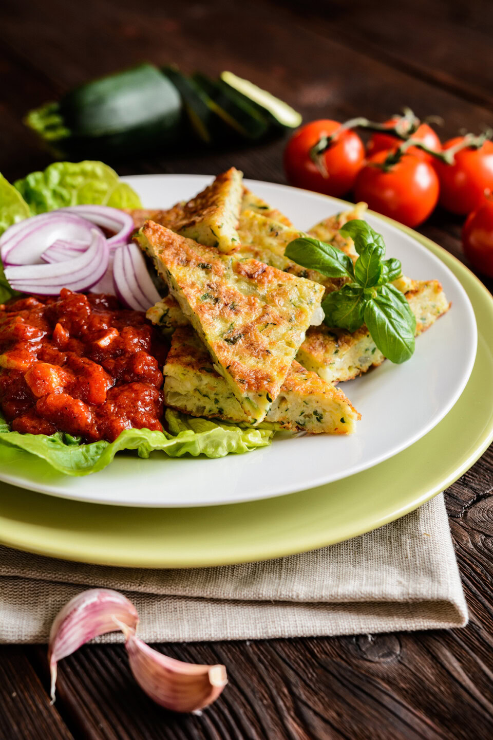 plate of zucchini fritters with puttanesca sauce